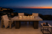 Alameda 60" Fire Table – Weathered Grey Woodgrain, front elevation, Malibu terrace at dusk.